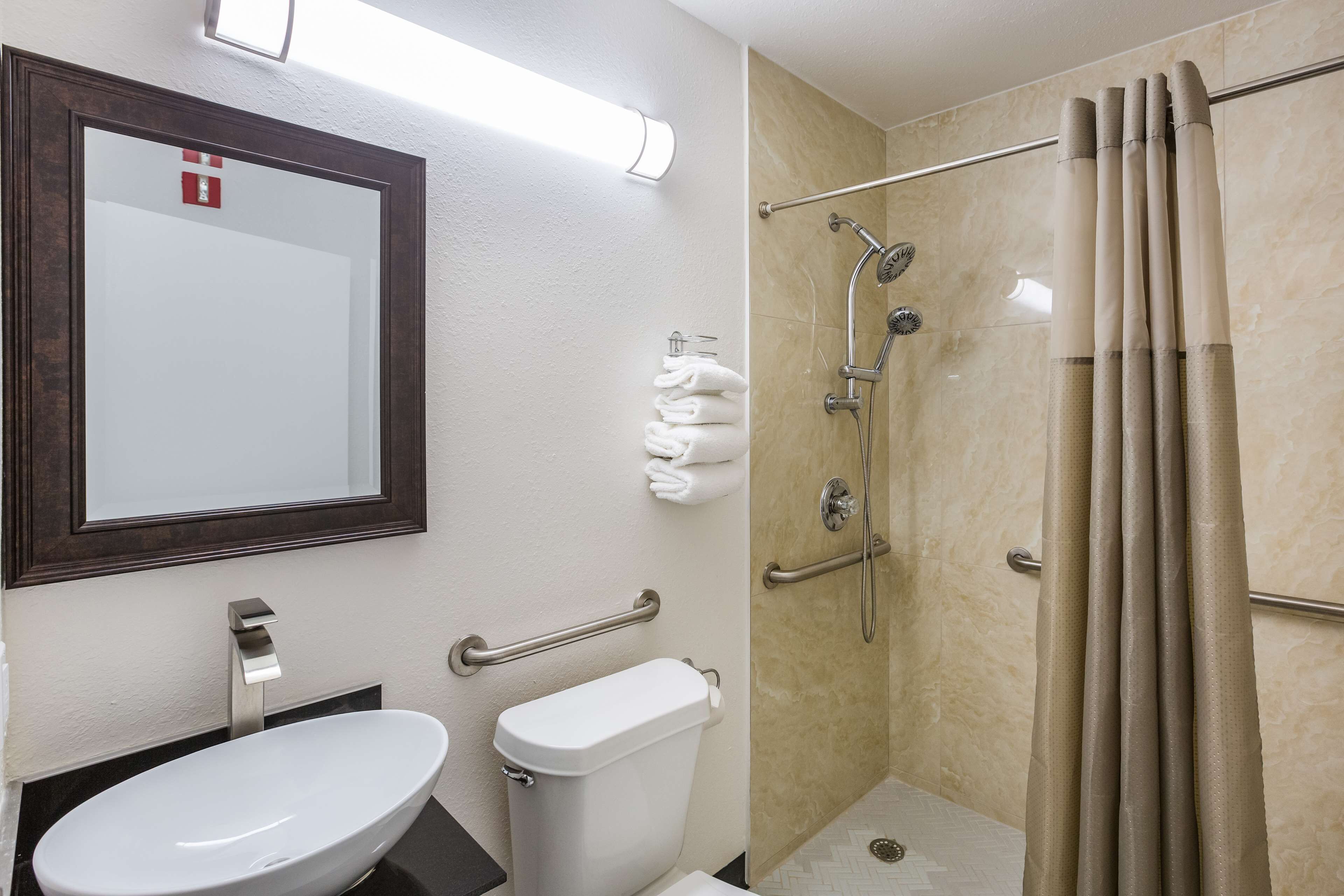A bathroom with a sink, toilet, and shower.