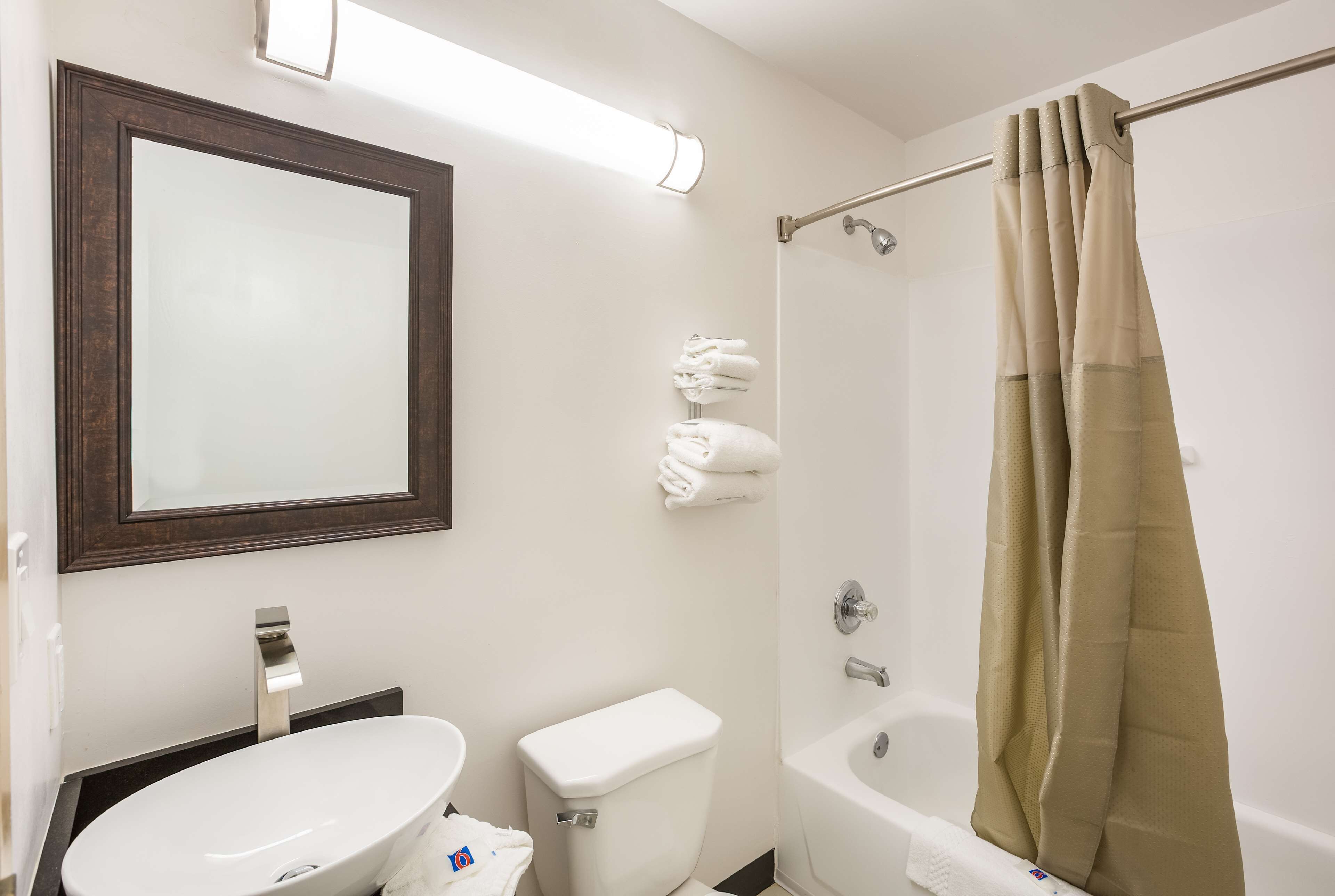 Un baño con lavamanos blanco, inodoro, bañera y cortina de ducha.