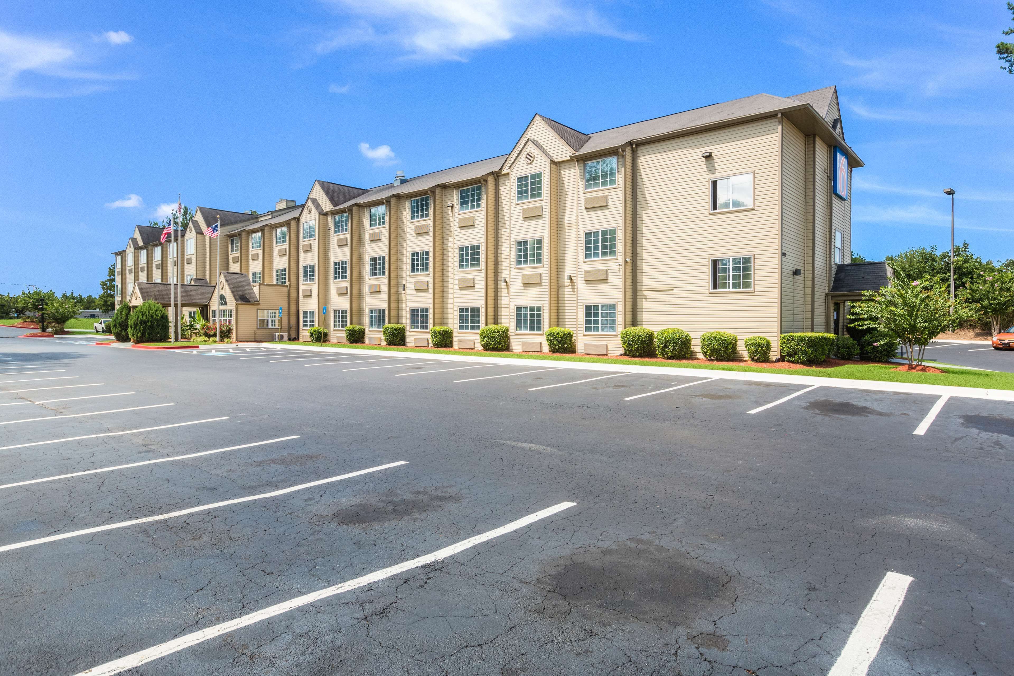 A multi-story hotel with a parking lot in front.