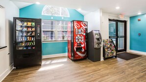 Ein Verkaufsautomatenbereich mit einem Coca-Cola Automaten, einem Snackautomaten und einem Geldautomaten.