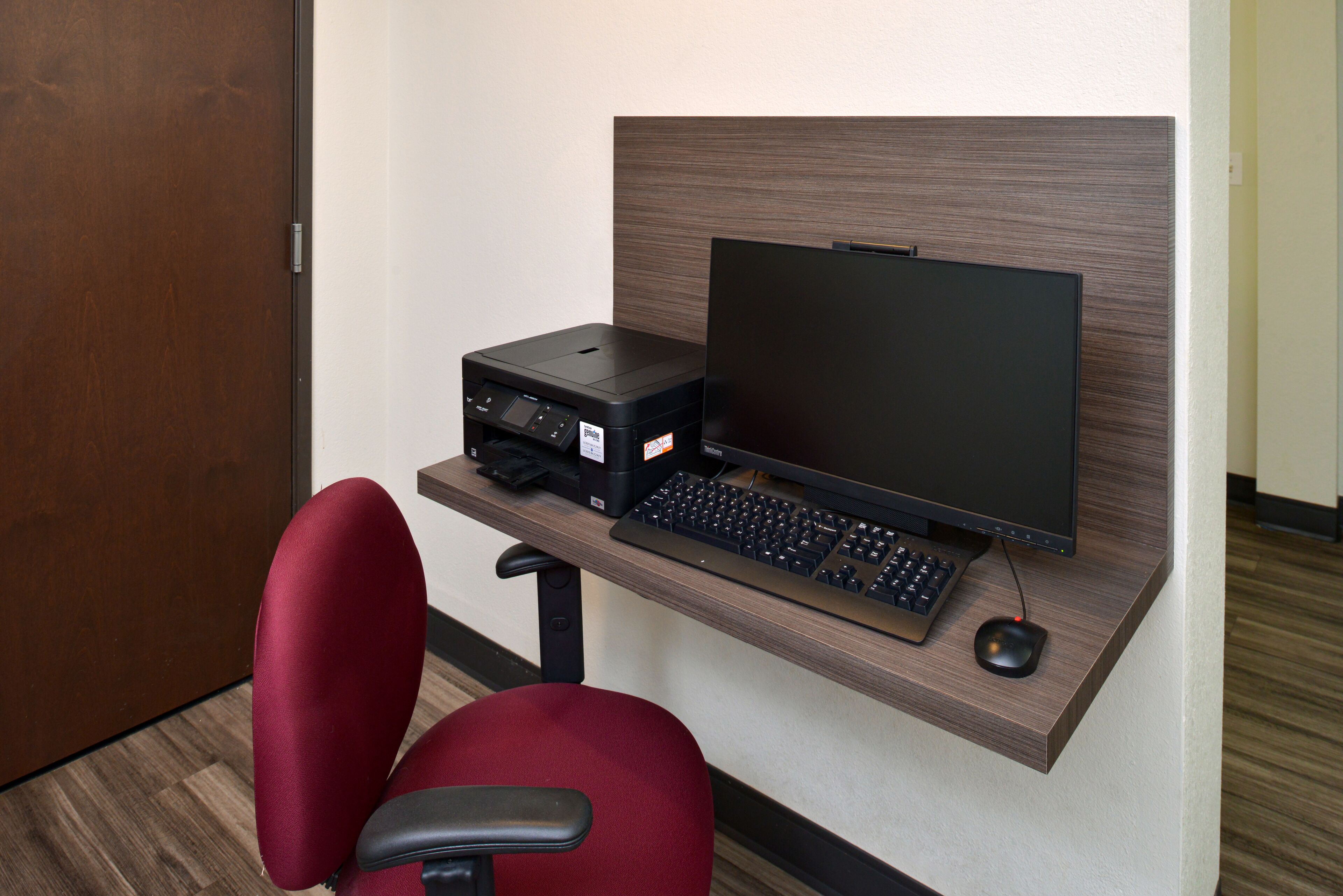 A compact office setup with a desk, a computer monitor, a keyboard, a mouse, and a printer.
