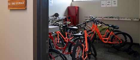 A bike storage area with multiple bicycles, a red cabinet, and a sign indicating the storage location.