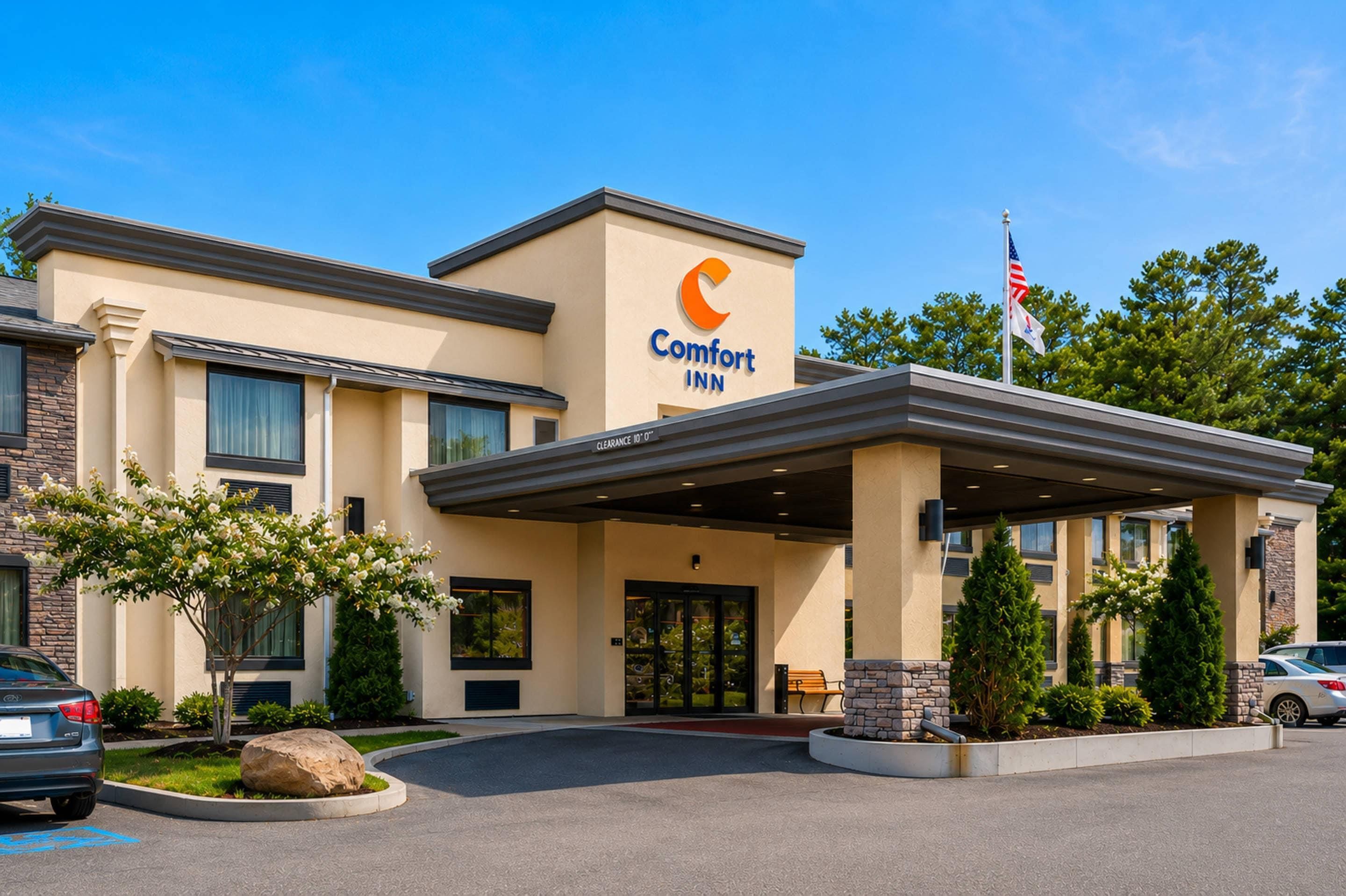 Ein Comfort Inn Hotel mit freiem Zugang, einem überdachten Außenbereich und einer Flagge.
