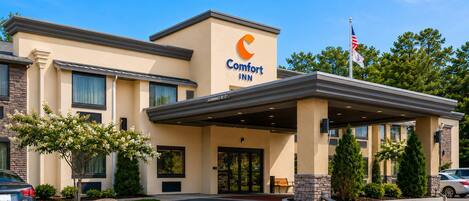 A Comfort Inn hotel with a clear entrance, a covered outdoor area, and a flag.