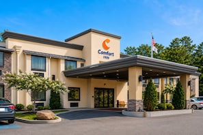 A Comfort Inn hotel with a clear entrance, a covered outdoor area, and a flag.