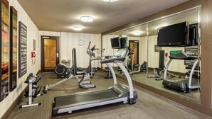 A hotel gym with treadmills, exercise bikes, and weights.