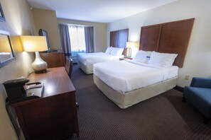 A hotel room with two beds, a desk with a lamp, a chair, and a window with curtains. - Comfort Inn Tupelo Central (Tupelo)