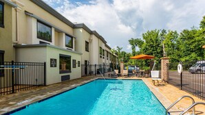 A swimming pool with a no diving sign, outdoor seating, and a brick wall. - Comfort Inn Tupelo Central (Tupelo)