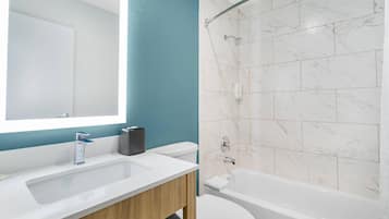 Un bagno con un lavandino bianco, uno specchio, un water e una vasca da bagno.