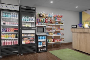 Eine Hotelhalle mit Verkaufsautomaten, Snackregalen und einer Rezeption.