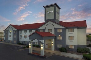 A hotel with a central tower, multiple floors, and a parking lot. - Spark by Hilton Denver Tech Center Centennial (Englewood)