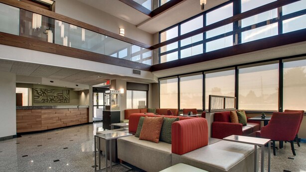 A spacious lobby with a high ceiling, large windows, and a reception desk. - Drury Inn & Suites Evansville East (Evansville)