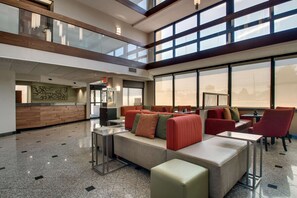 A spacious lobby with a high ceiling, large windows, and a reception desk. - Drury Inn & Suites Evansville East (Evansville)