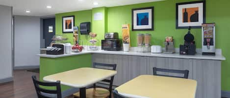 Un comedor con barra, asientos y electrodomésticos de cocina.