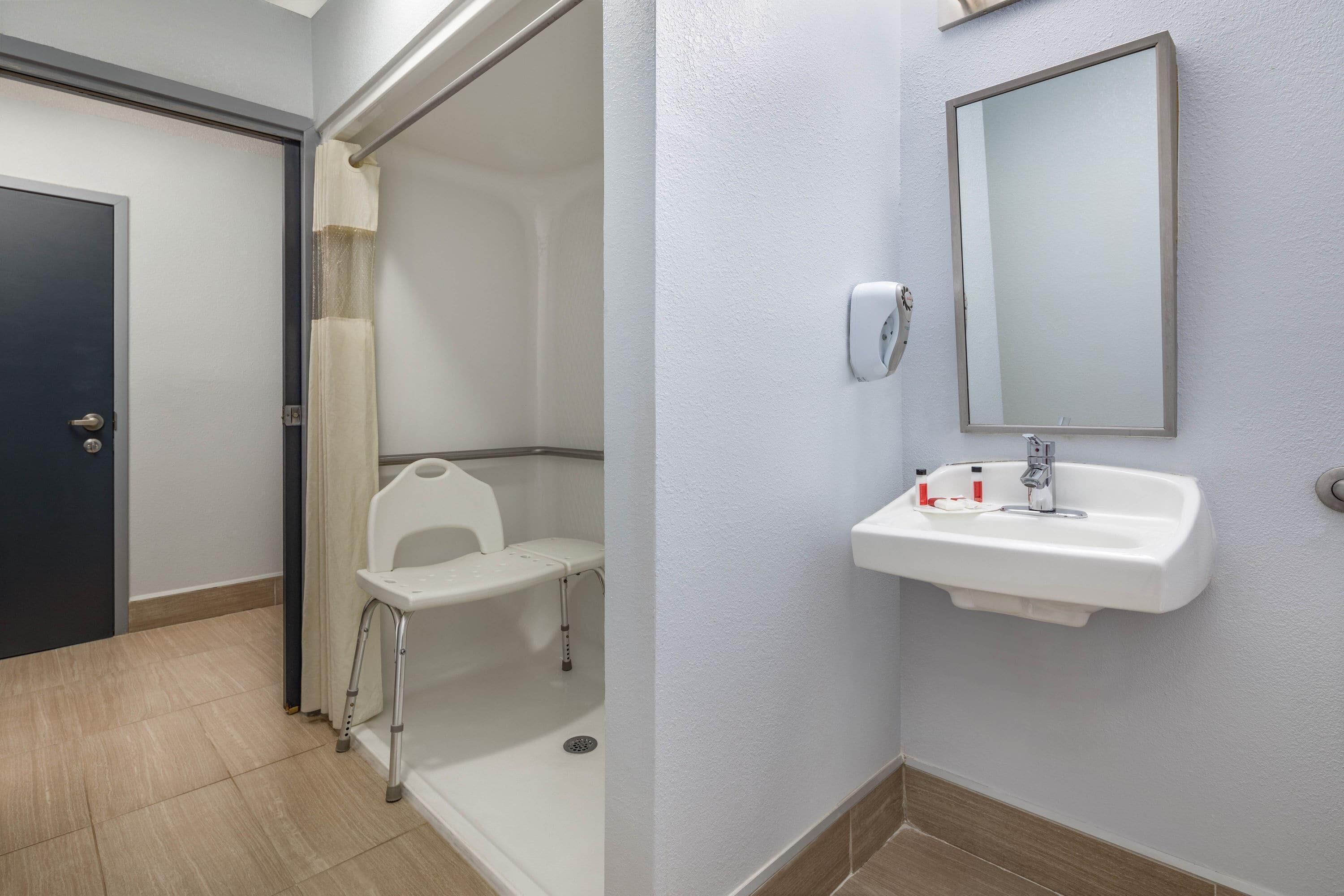 Un baño con ducha, lavabo y espejo.