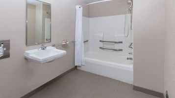A modern bathroom with a white sink, mirror, and shower.