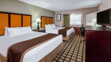 A hotel room with two beds, a desk, a chair, and a television.