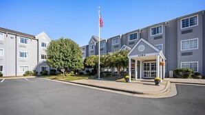 A multi-story residential building with a covered entrance and a flagpole. - Microtel Inn by Wyndham Greensboro (Greensboro)