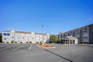 A Microtel Inn with a parking lot and a small entrance building. - Microtel Inn by Wyndham Greensboro (Greensboro)