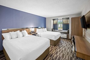 A hotel room with two beds, a desk, a TV, and a window with curtains. - Microtel Inn by Wyndham Greensboro (Greensboro)