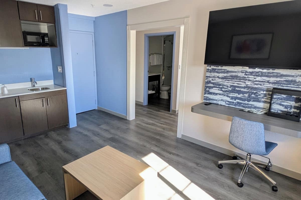 Escritorio, cortinas blackout y tabla de planchar con plancha