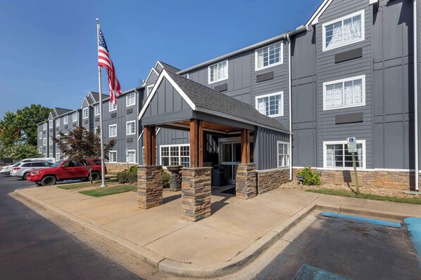 Stunning multi-story building with a covered entrance and stone pillars.