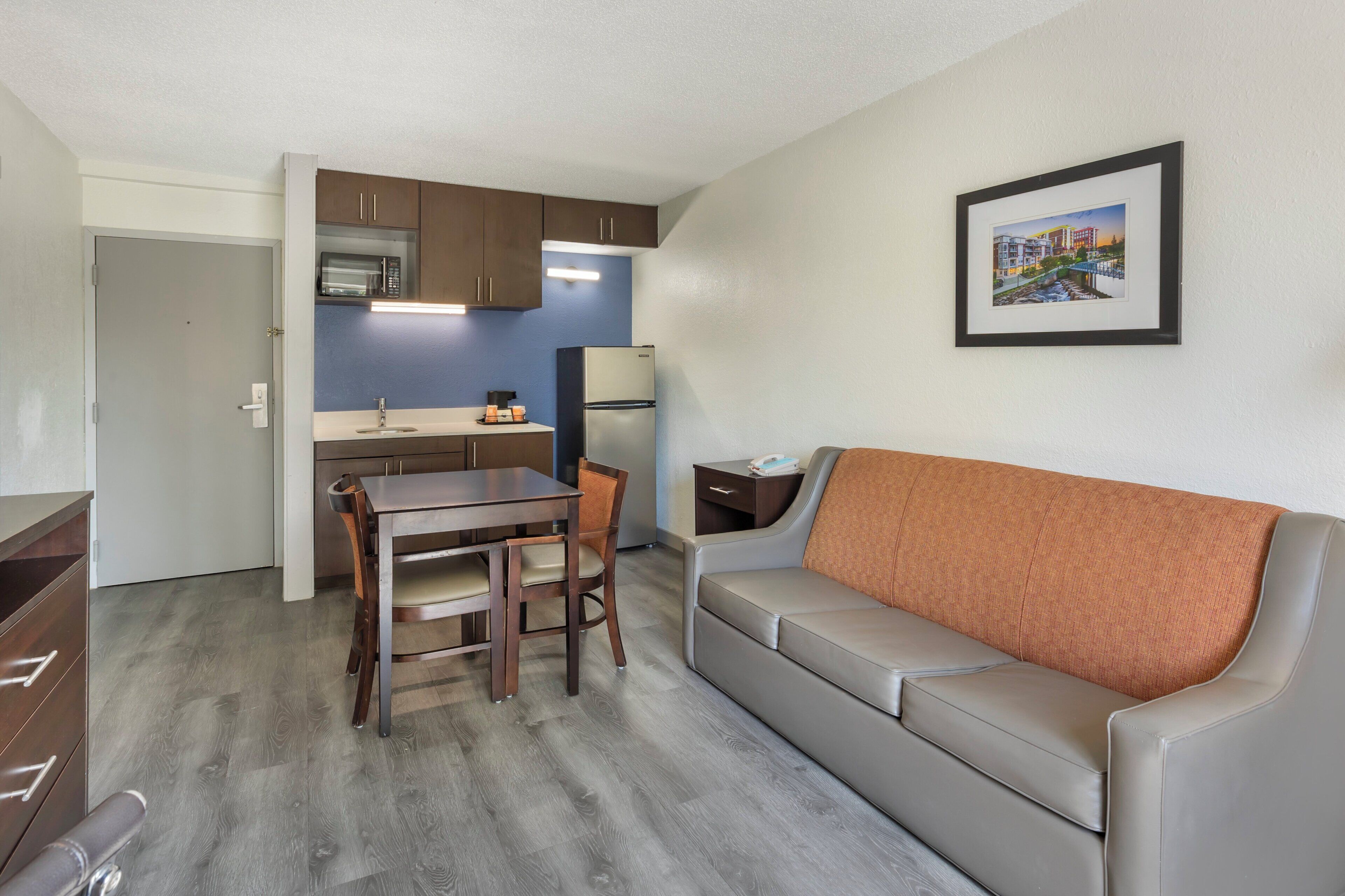 A compact living space with a kitchenette, a dining area, and a sofa.