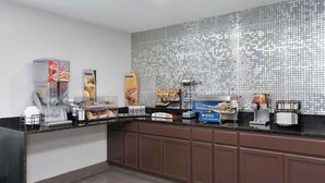 Un buffet pour le petit-déjeuner proposant des céréales, du pain et différentes sortes de café.