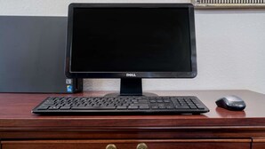 A Dell monitor on a wooden desk with a keyboard and a mouse. - Microtel Inn by Wyndham Onalaska/La Crosse (Onalaska)