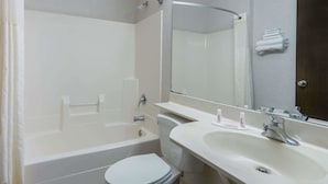A bathroom with a bathtub, toilet, sink, and a mirror. - Microtel Inn by Wyndham Onalaska/La Crosse (Onalaska)