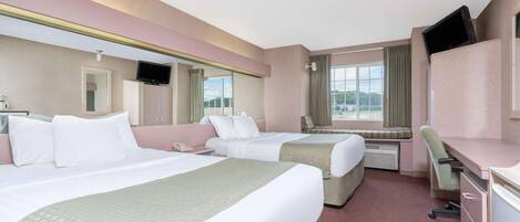 A hotel room with two beds, a desk, a chair, a TV, and a window with a view.