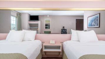 A hotel room with two beds, a small table with a phone, a TV, a coffee maker, and a painting on the wall.