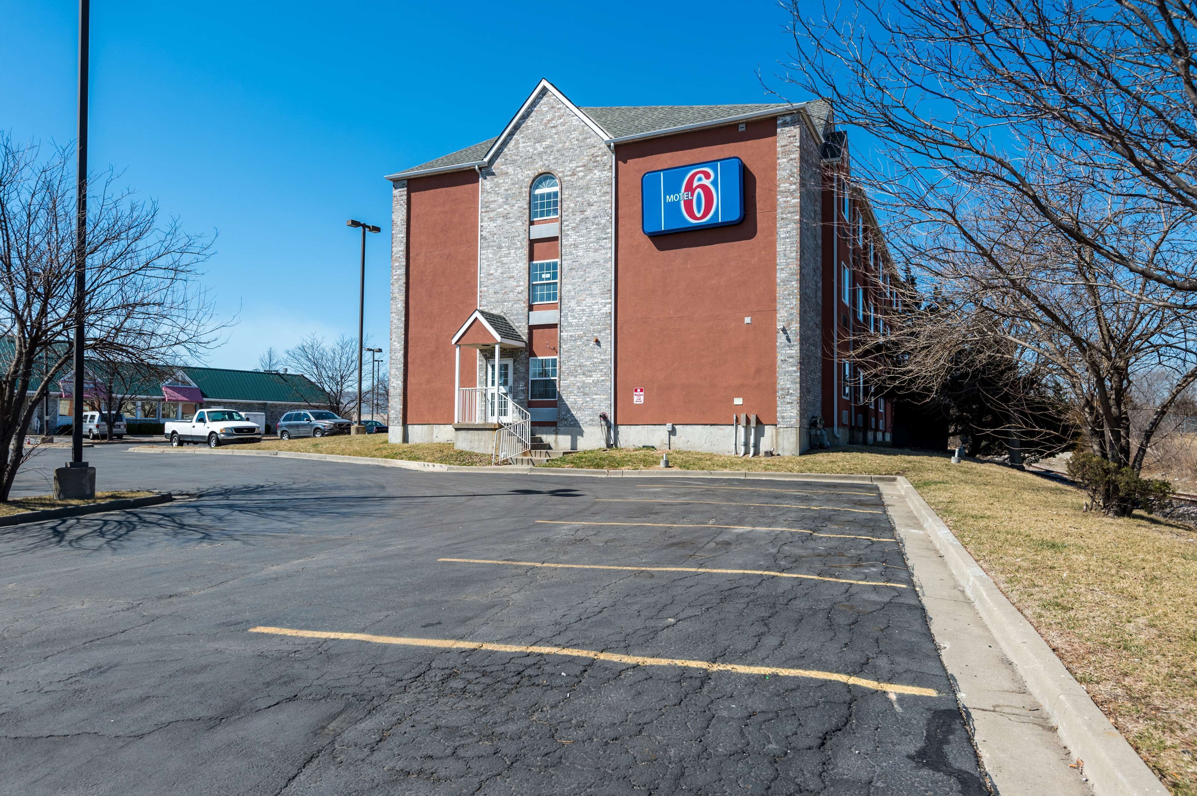 A motel with a prominent '6' sign, a brick facade, and a parking lot.