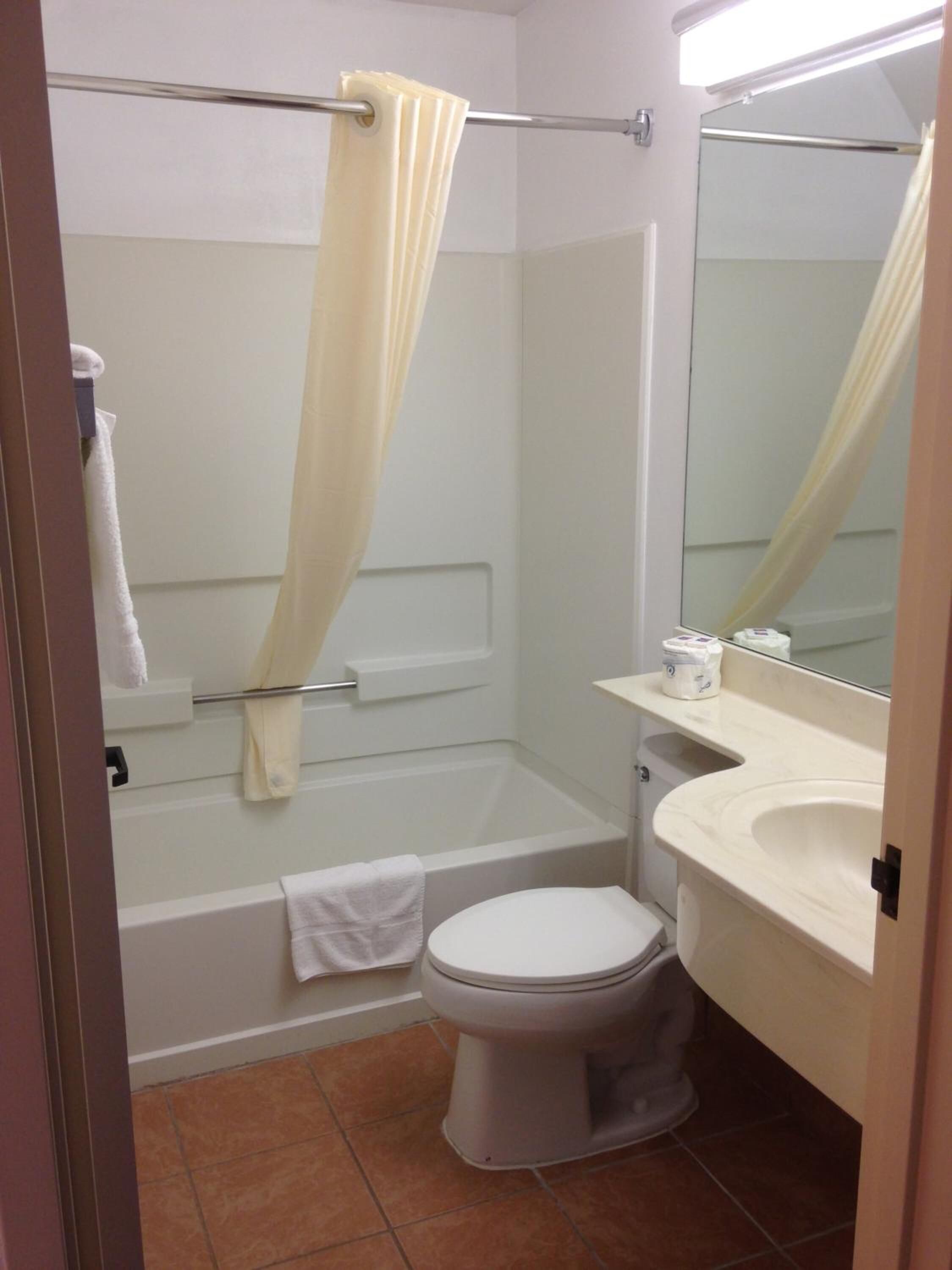 A bathroom with a bathtub, toilet, and sink.