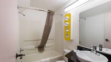 A bathroom with a bathtub, toilet, sink, and a mirror.