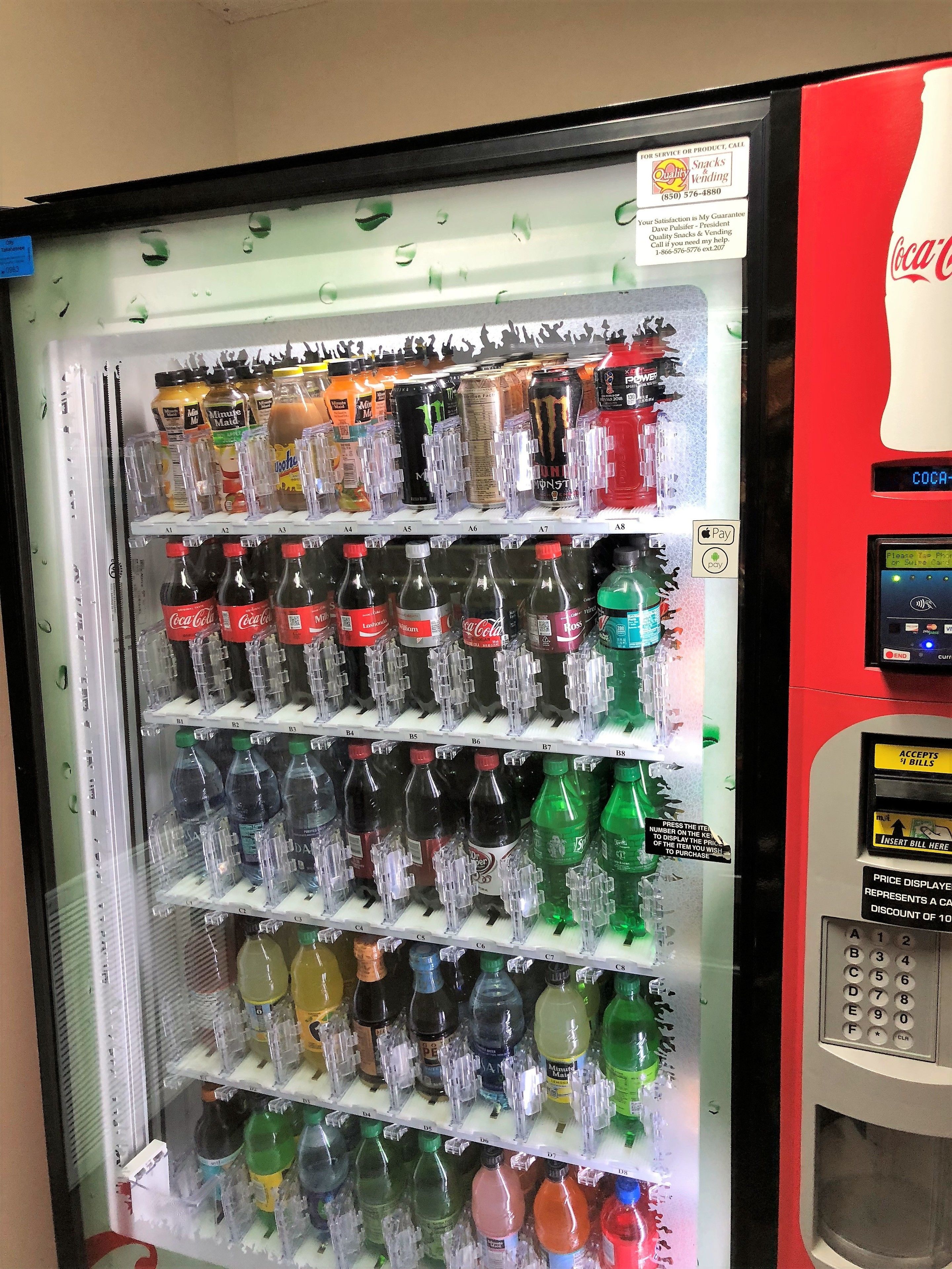 Un distributeur automatique rempli de diverses boissons et collations, notamment du Coca-Cola et du jus Minute Maid.