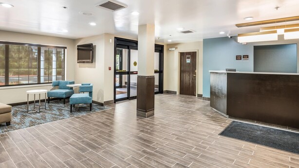 A hotel lobby with a reception desk, seating area, and large windows. - Sleep Inn & Suites Tallahassee-Capitol (Tallahassee)