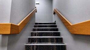 A staircase with wooden handrails and black patterned steps. - Guest Inn Pigeon Forge (Pigeon Forge)