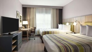 A hotel room with a bed, a desk with a computer, a television, and a window with curtains. - Country Inn & Suites by Radisson Bismarck Waterpark (Bismarck)