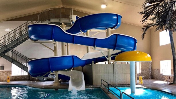 An indoor water park with multiple blue slides and a pool. - Country Inn & Suites by Radisson Bismarck Waterpark (Bismarck)