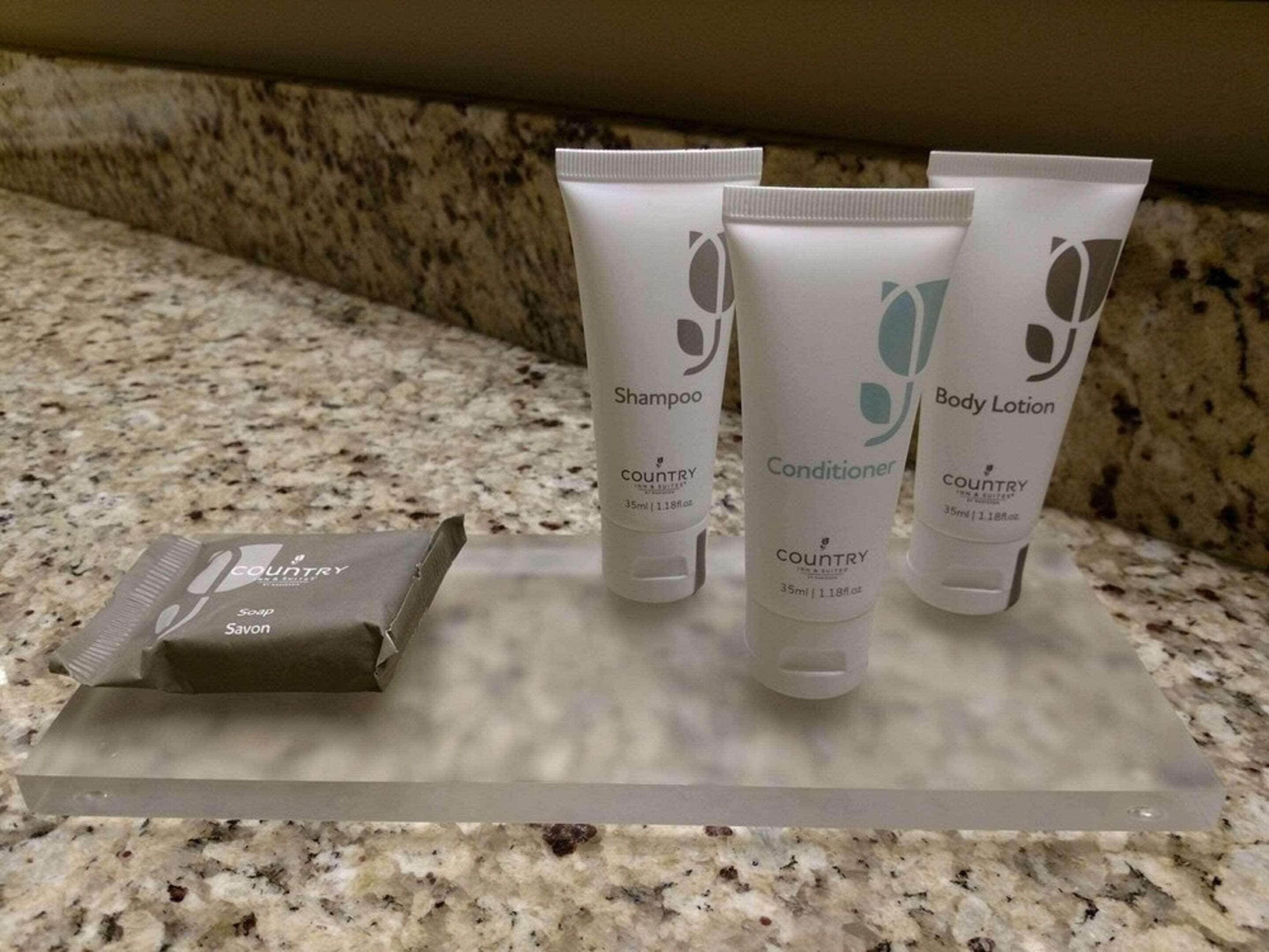 A countertop with three toiletry containers labeled 'COUNTRY' and a soap bar.