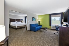A hotel room with a bed, a blue sofa, a desk, and a TV. - Holiday Inn Express Chillicothe East by IHG (Chillicothe)
