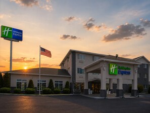 A Holiday Inn Express building with a clear view of the entrance, flag, and surrounding greenery. - Holiday Inn Express Pendleton by IHG (Pendleton)