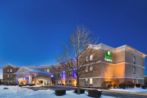 A Holiday Inn Express hotel with a brick facade, multiple entry points, and a parking lot with snow. - Holiday Inn Express Harrisburg I-81 – Hershey by IHG (Harrisburg)