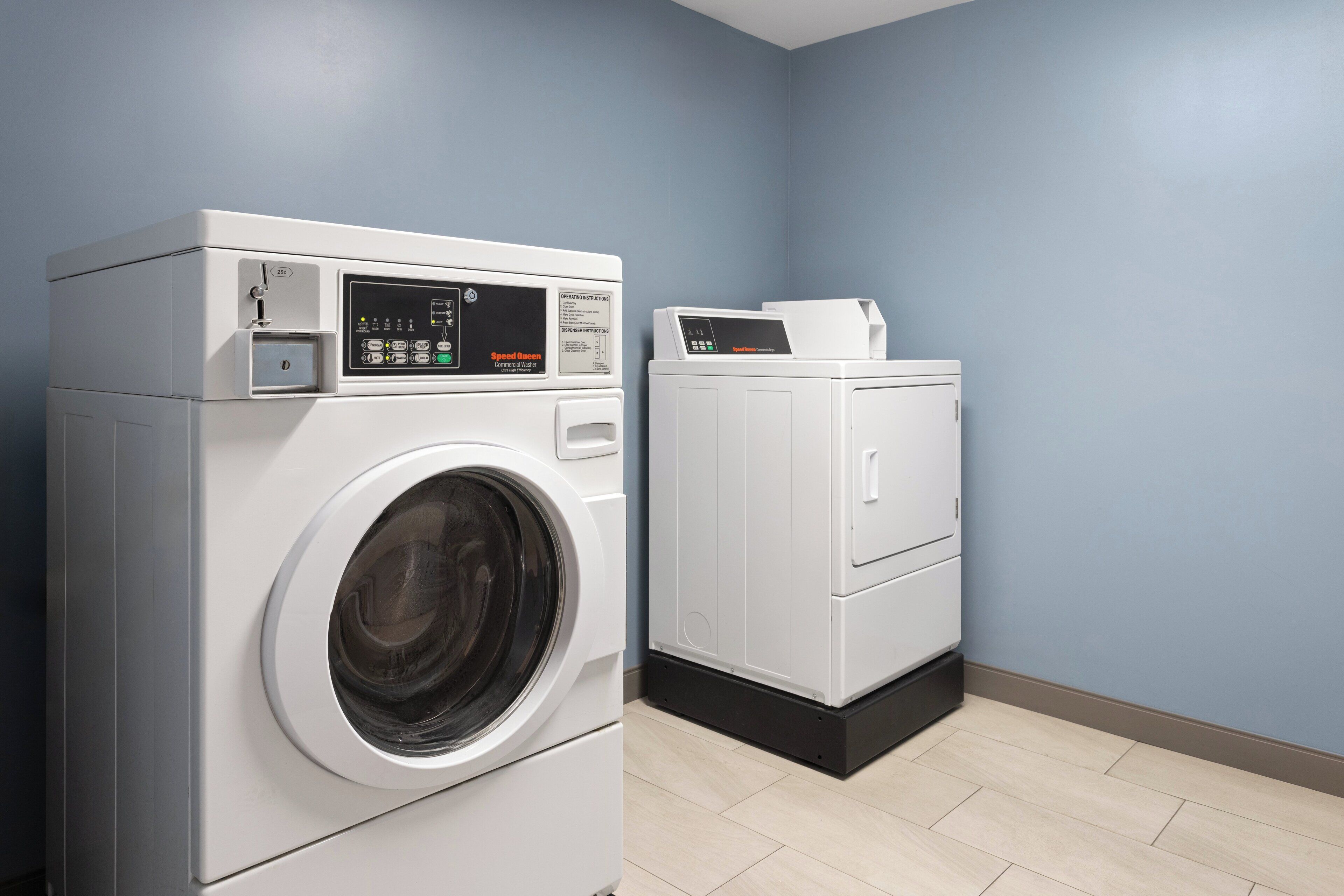 A laundry room with a front-loading washing machine and a stacked dryer.