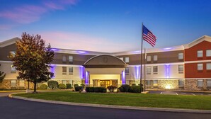 A hotel with a central entrance, a flag, and a well-maintained lawn. - Holiday Inn Express Harrisburg I-81 – Hershey by IHG (Harrisburg)