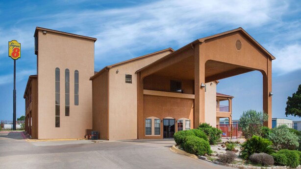 A beige building with a Super 8 sign, a covered entrance, and a parking lot.