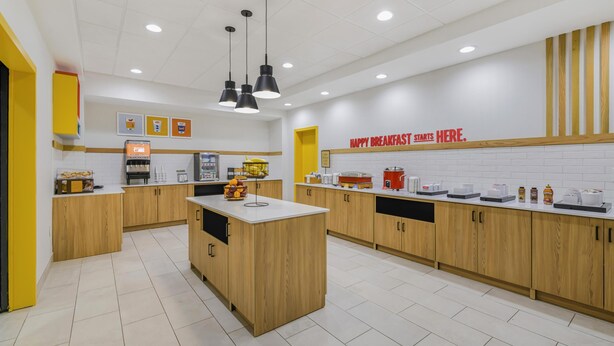 A modern kitchen with wooden cabinets, a central island, and various appliances. - Hampton Inn Huntsville-Arsenal/South Pkway (Huntsville)