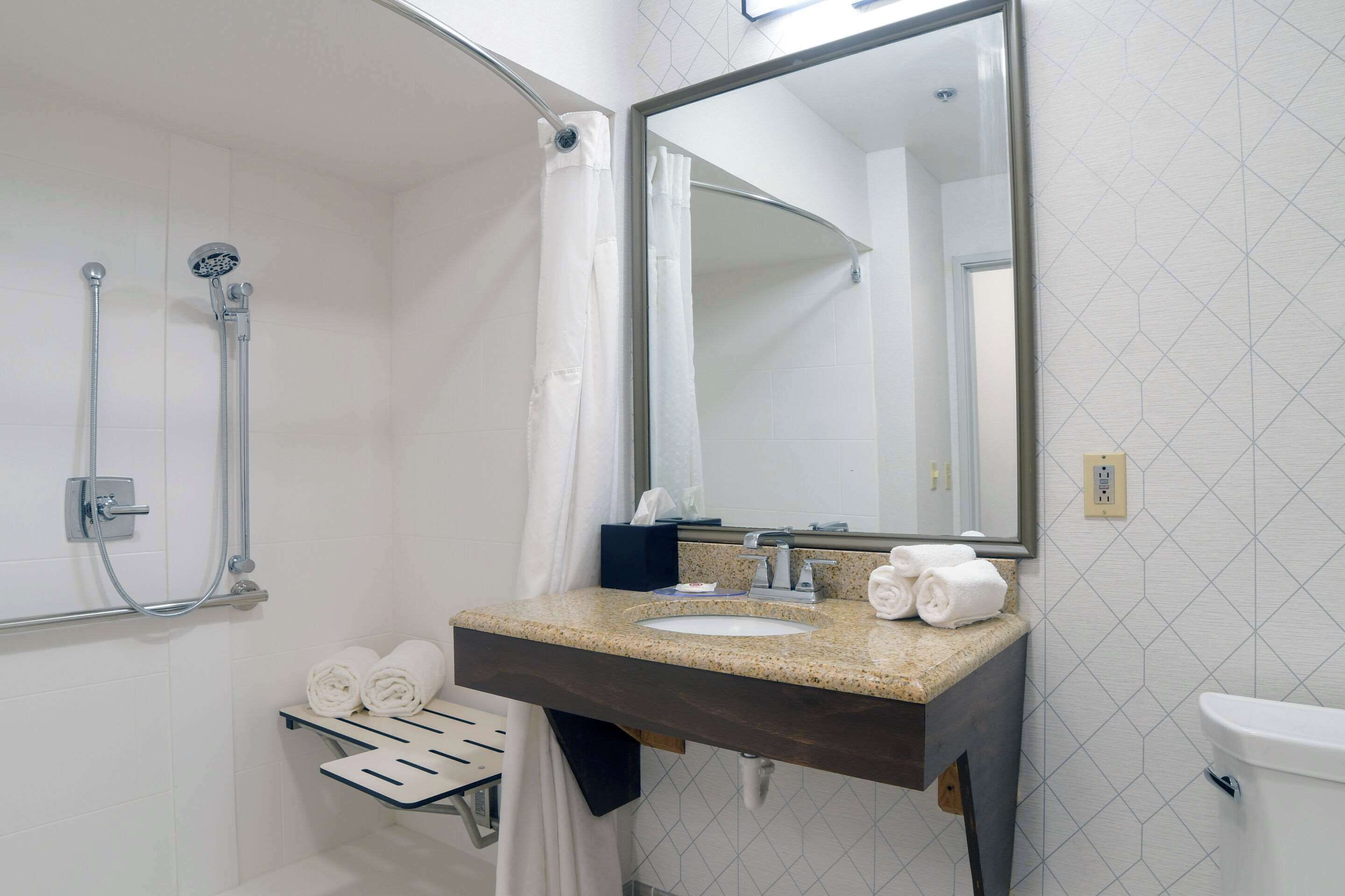 Une salle de bain avec douche, lavabo et toilettes.