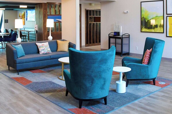 Un salon moderne comprenant un canapé, deux fauteuils et une petite table.